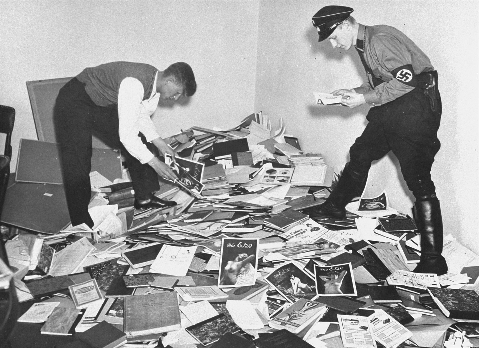 Two men examine books and papers taken from the Institute for Sexual Science in Berlin in May 1933.
